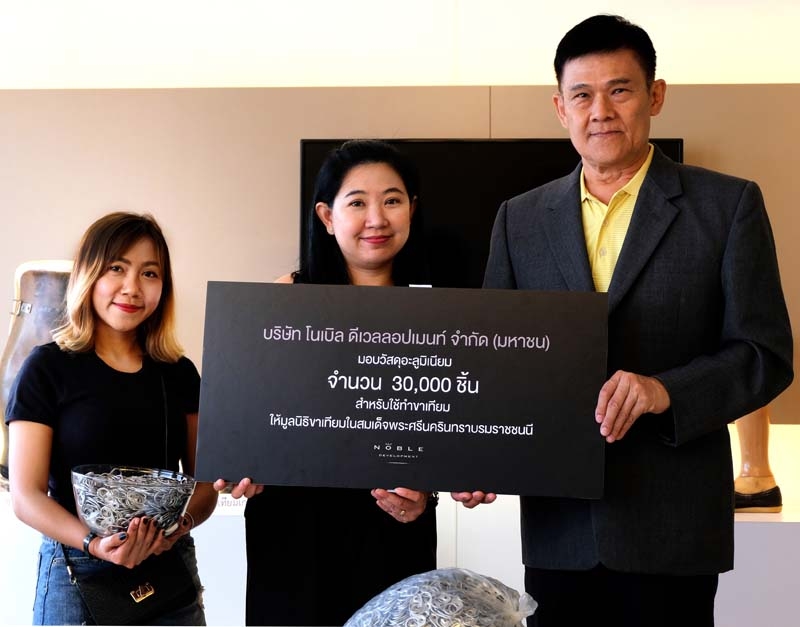 รักษ์โลก..ร่วมแบ่งปัน : อัจฉรา สุริยาประสิทธิ์ ผช.ผจก.ฝ่ายการตลาดฯ บมจ.โนเบิล ดีเวลลอปเมนท์ มอบวัสดุอะลูมิเนียม 30,000 ชิ้น จากการบริจาคของผู้ร่วมงาน Noble Play Around Ari ให้แก่ ไกรเดช เถลิงเกียรติ รองเลขาธิการมูลนิธิขาเทียมฯ