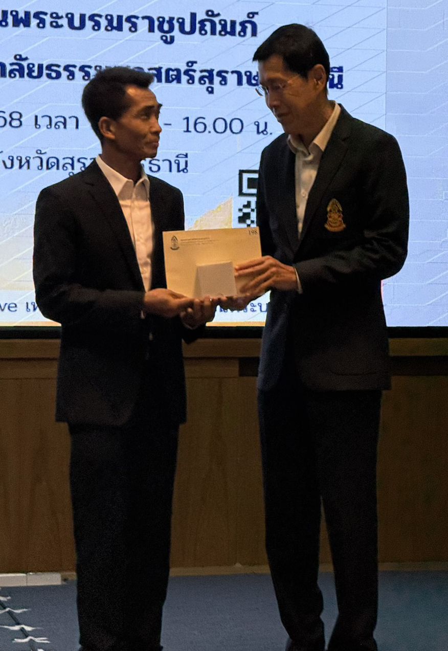 พงศ์เทพ เทพกาญจนา นายกสมาคมธรรมศาสตร์ มอบของที่ระลึกแก่ มี สิทธิชัย ไทยเจริญ ประธานชมรมธรรมศาสตร์ สุราษฎร์ธานี