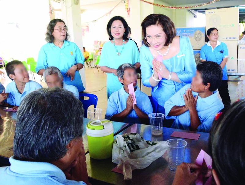 คุณหญิงปัทมา ลีสวัสดิ์ตระกูล ประธานชมรมผู้รู้คุณแผ่นดิน และคณะกรรมการชมรมฯ ช่วยกันมอบของขวัญและของว่างให้กับผู้รับการสงเคราะห์