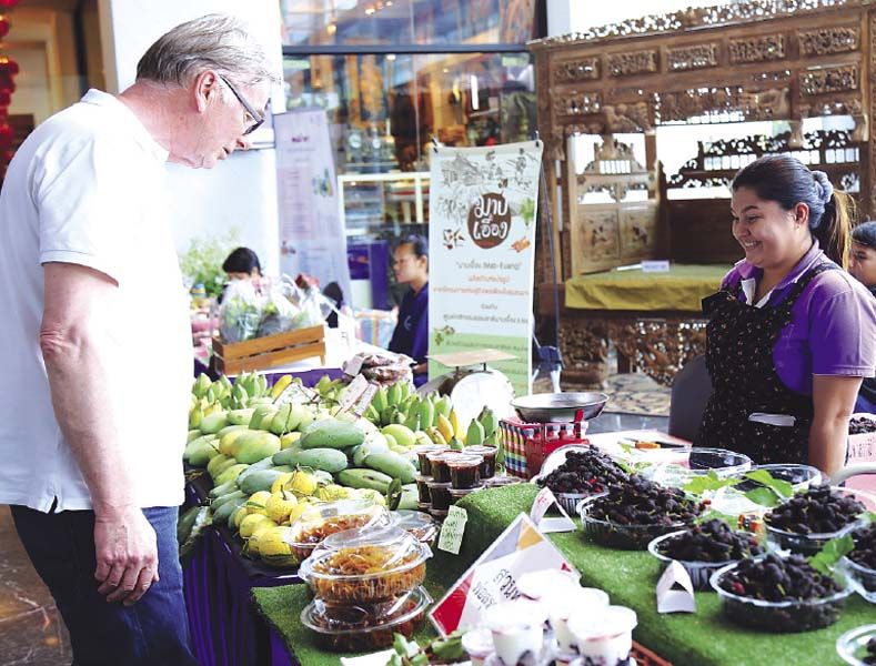 แขกภายในงานเลือกซื้อผลิตภัณฑ์โอท็อปและผลิตภัณฑ์จากโครงการเศรษฐกิจพอเพียงในชุมชนมาบเอื้อง จ.ชลบุรี