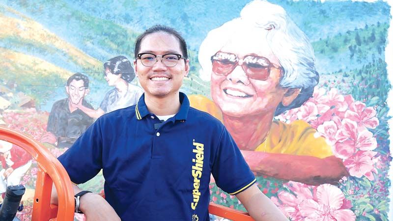 ชวัส จาปาแสน หนึ่งในทีมศิลปินจิตอาสา HAPPENING ถ่ายภาพคู่กับผลงานการวาดภาพ โครงการสตรีทอาร์ต คิง ภูมิพล ด้วยความภาคภูมิใจ