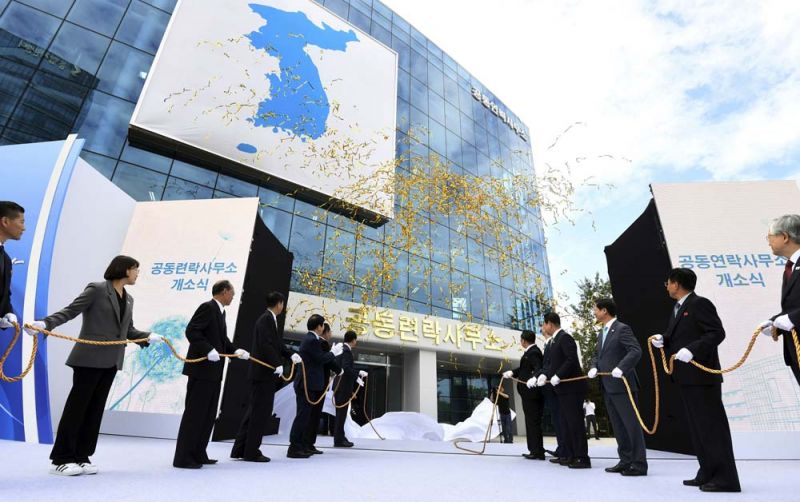 เจ้าหน้าที่ของเกาหลีเหนือและเกาหลีใต้ถ่ายภาพร่วมกัน ในพิธีเปิดศูนย์ประสานงานร่วมที่นิคมแกซอง เมื่อเดือนก.ย. 2561