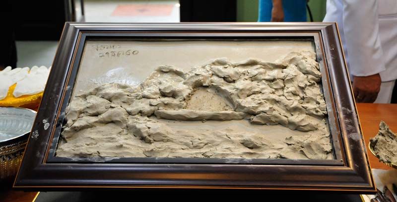 ทรงวาดลวดลายบนแผ่นปูนปั้นด้วยเครื่องมือปั้น