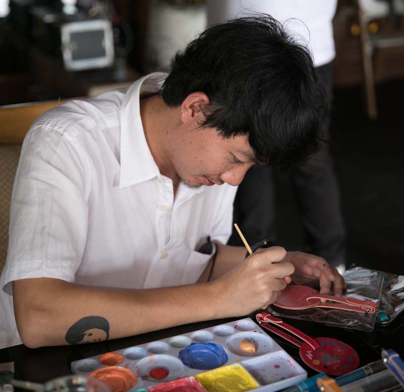 ธนกร ประกอบของ ศิลปินชื่อดังขณะเพ้นท์แท็กกระเป๋าอย่างมีสไตล์