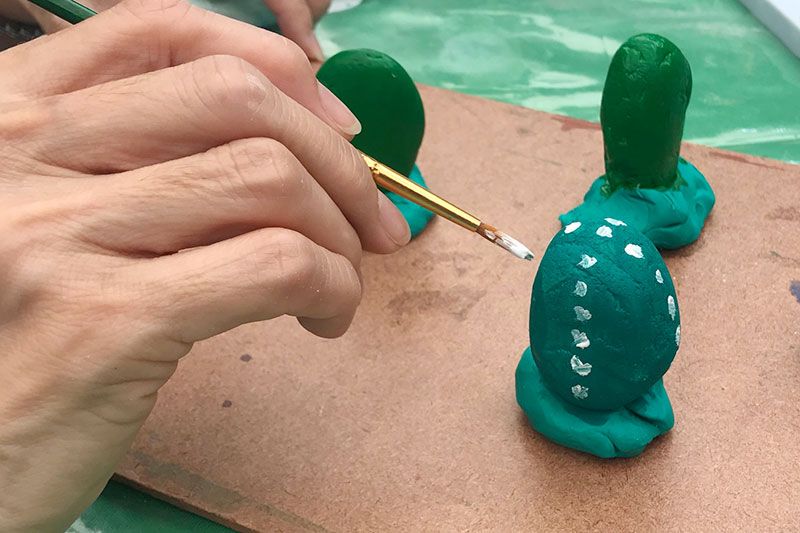 เริ่มต้นการทำด้วยการลงสีโทนเข้มลงบนหิน พร้อมวาดลวดลาย

