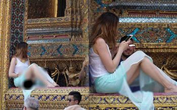 โซเชียลจวกยับ! แหม่มสาวนั่งโพสท่าไม่แคร์โลกในวัดพระแก้ว