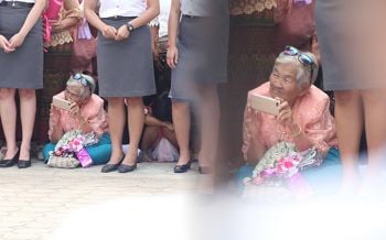 สุดน่ารัก! คุณยายนั่งลงกับพื้น รอถ่ายรูปหลานที่กำลังเดินมาในขบวนบัณฑิต